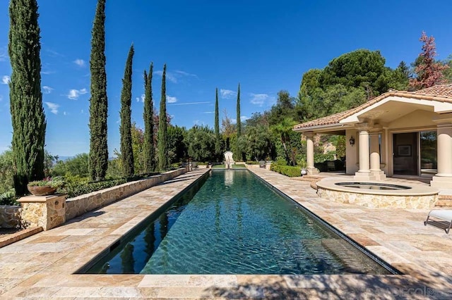 view of swimming pool featuring a patio area and an in ground hot tub