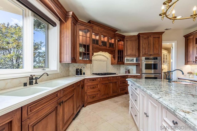 kitchen with sink, white cabinets, decorative backsplash, and appliances with stainless steel finishes