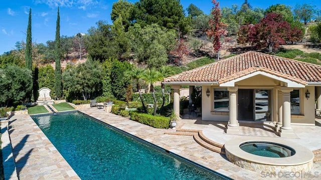 view of swimming pool featuring a patio area, an in ground hot tub, and an outdoor structure