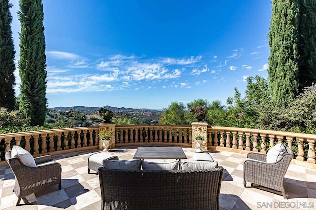 wooden terrace with a patio area and a mountain view