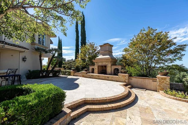 view of patio with an outdoor fireplace