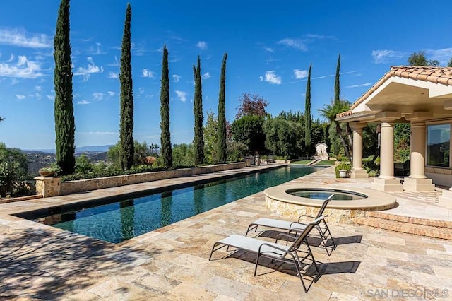 view of swimming pool featuring an in ground hot tub and a patio area