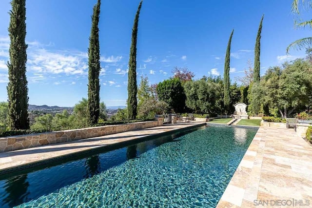 view of pool with a patio area and a mountain view