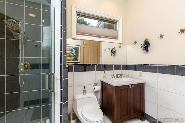 bathroom featuring toilet, vanity, tile walls, and tiled shower