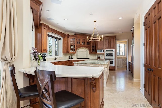 kitchen with double oven, kitchen peninsula, and a kitchen bar