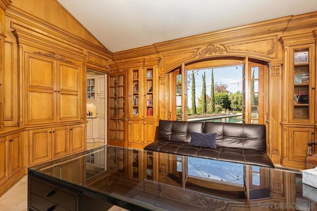 living area with wood walls and vaulted ceiling