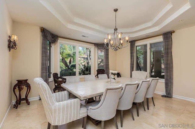 dining room with a raised ceiling and a chandelier