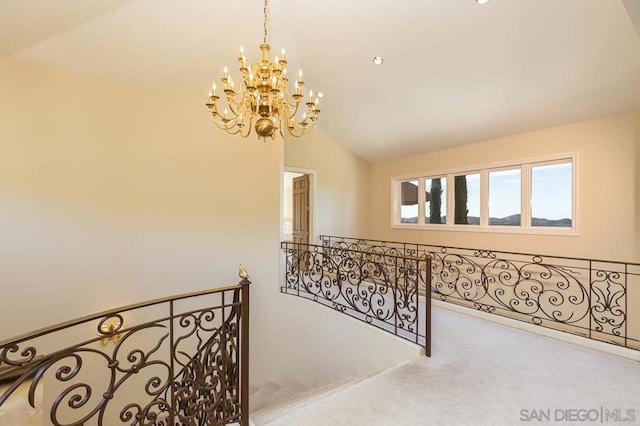 hall with a notable chandelier, lofted ceiling, and carpet floors