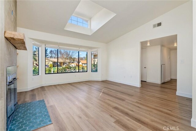 unfurnished living room with vaulted ceiling and light hardwood / wood-style floors