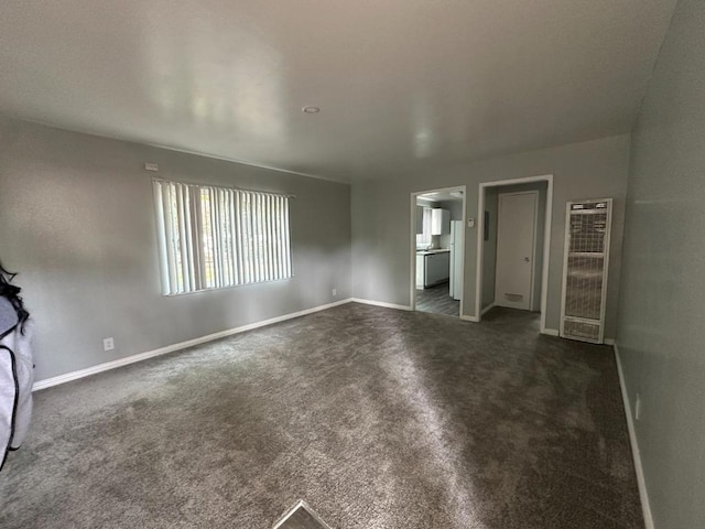 unfurnished bedroom featuring ensuite bath and dark colored carpet