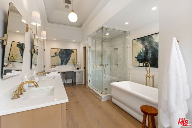 bathroom featuring independent shower and bath, ornamental molding, wood-type flooring, and vanity