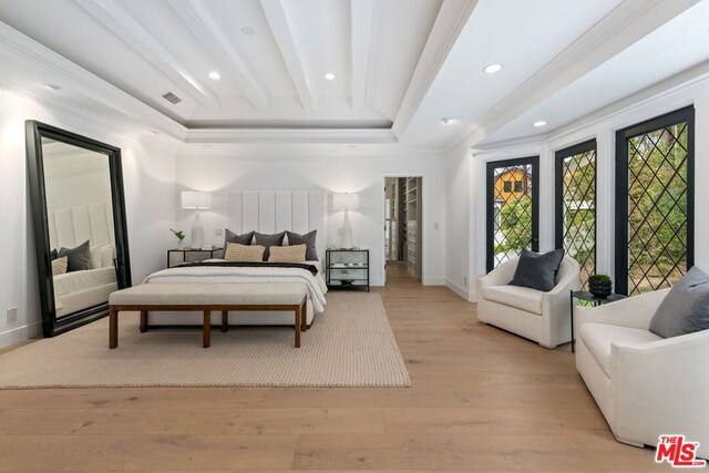 bedroom featuring a raised ceiling, ornamental molding, light hardwood / wood-style floors, and beam ceiling