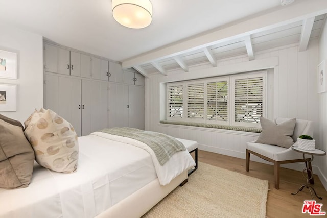 bedroom featuring light hardwood / wood-style floors and lofted ceiling with beams