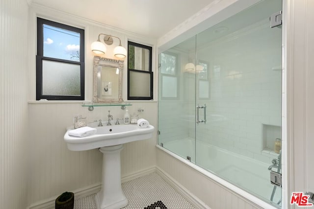 bathroom featuring tile patterned flooring, bath / shower combo with glass door, and ornamental molding