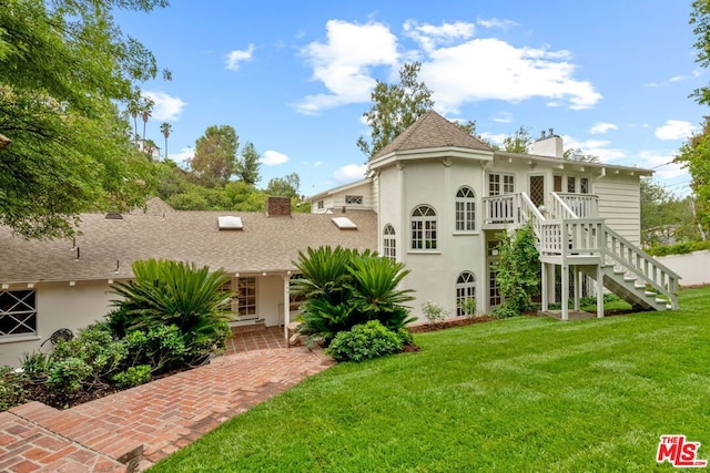 rear view of house featuring a yard