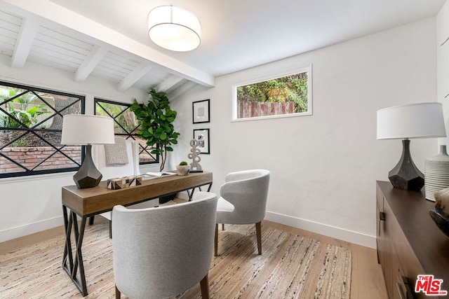 home office featuring light hardwood / wood-style floors and vaulted ceiling with beams