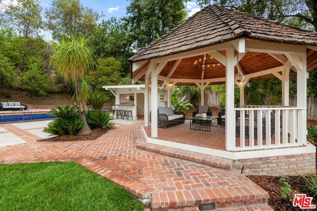 view of patio / terrace with a gazebo, an outdoor hangout area, a bar, and a wooden deck