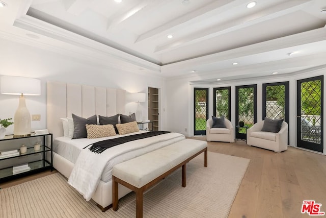 bedroom featuring a tray ceiling, crown molding, and light hardwood / wood-style flooring