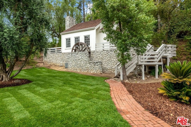 view of yard featuring a deck and an outbuilding