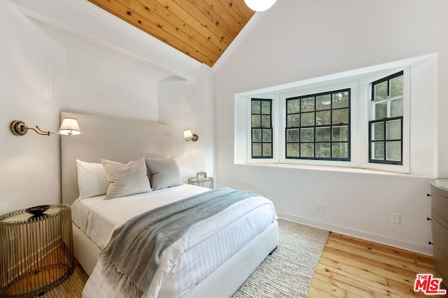 bedroom with light wood-type flooring, wooden ceiling, and lofted ceiling