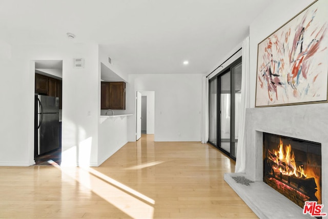 unfurnished living room featuring light hardwood / wood-style floors and a premium fireplace