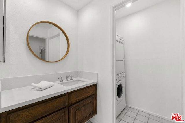 bathroom with vanity, stacked washer / drying machine, and tile patterned flooring