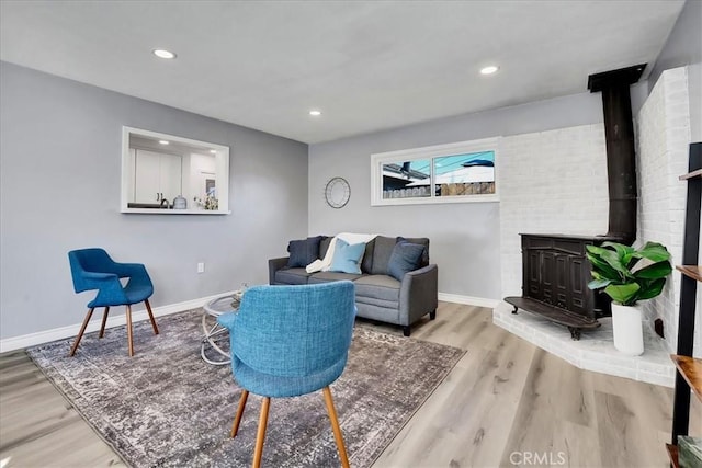 living room with light hardwood / wood-style floors and a wood stove