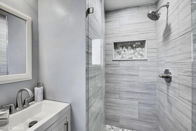 bathroom featuring a tile shower and vanity