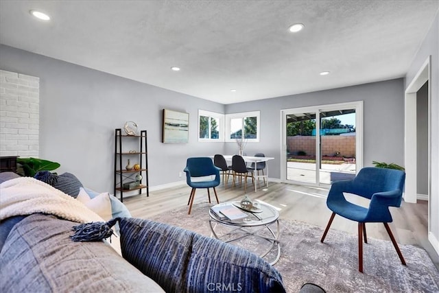 living room with a healthy amount of sunlight, light wood-type flooring, and a fireplace