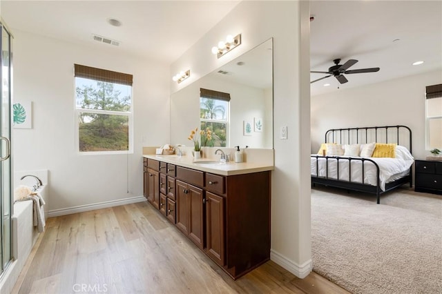 bathroom with vanity, ceiling fan, hardwood / wood-style flooring, and a bath