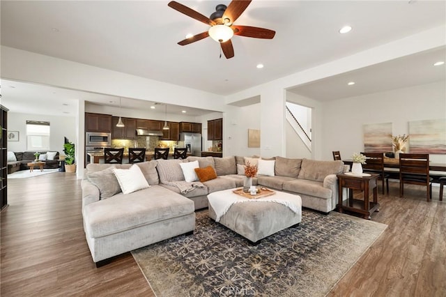 living room with dark wood-type flooring and ceiling fan