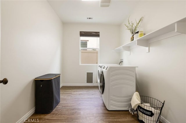 clothes washing area featuring washer and dryer and wood-type flooring