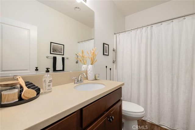 bathroom featuring wood-type flooring, vanity, and toilet