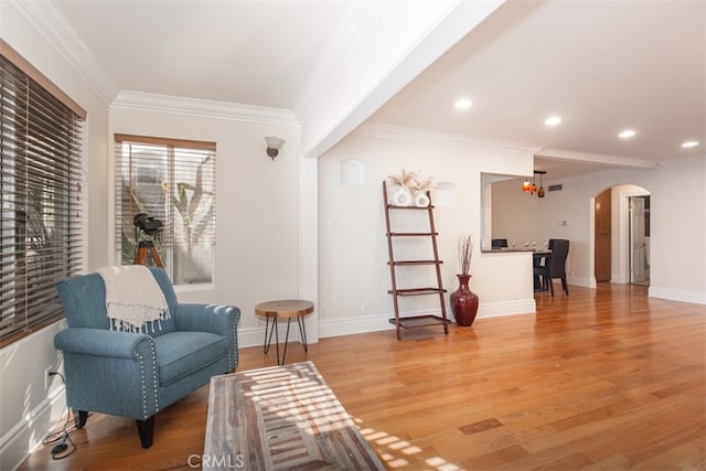 sitting room featuring light hardwood / wood-style floors, ornamental molding, and a notable chandelier