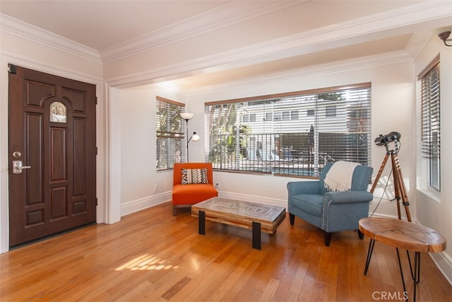 sitting room featuring ornamental molding, baseboards, and light wood finished floors