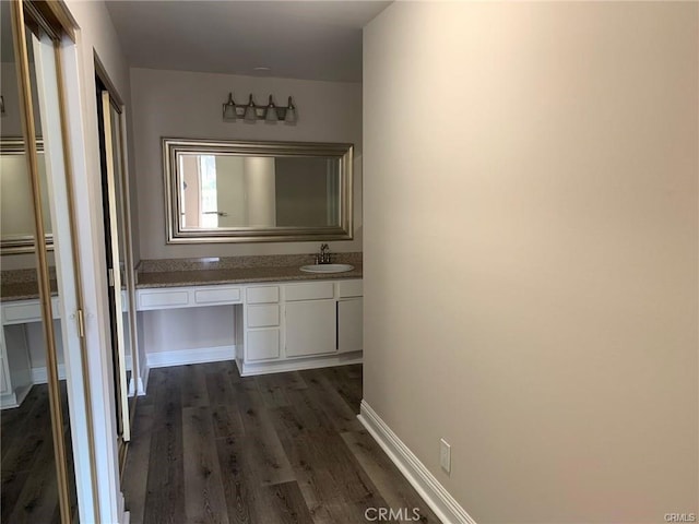 corridor featuring dark wood-type flooring and sink