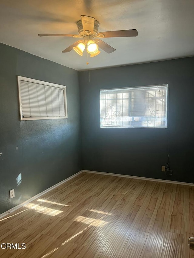 unfurnished room with ceiling fan and hardwood / wood-style flooring