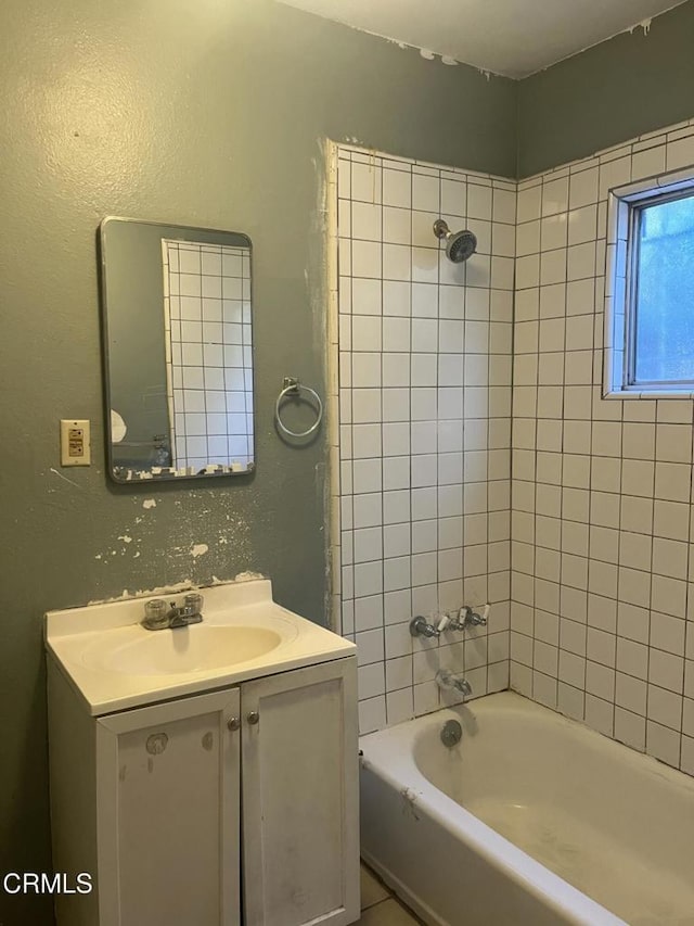 bathroom featuring tiled shower / bath and vanity