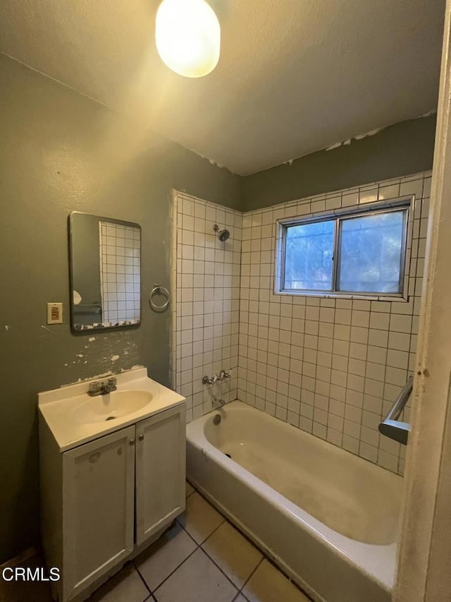 bathroom featuring tile patterned flooring, tiled shower / bath, and vanity