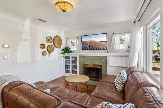 living room featuring hardwood / wood-style flooring and a tile fireplace