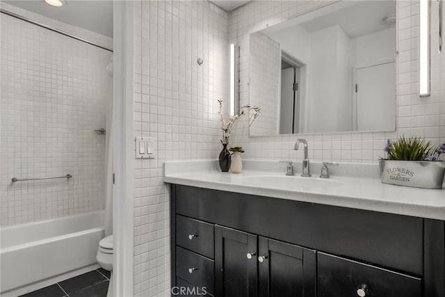 full bathroom with toilet, tile patterned floors, tile walls, and tub / shower combination