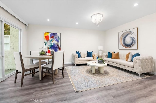 living room featuring an inviting chandelier and hardwood / wood-style floors