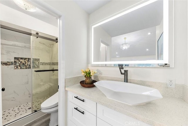 bathroom with toilet, walk in shower, vanity, and hardwood / wood-style floors