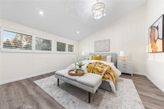 bedroom featuring a notable chandelier, dark wood-type flooring, and lofted ceiling