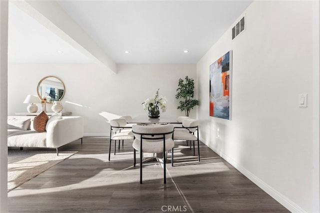 dining room with dark wood-type flooring and beamed ceiling