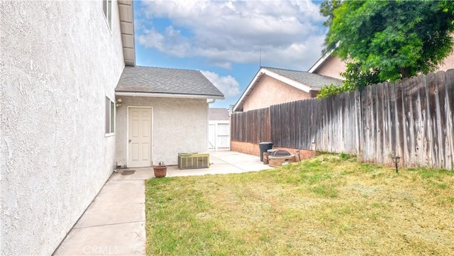 view of yard with central AC and a patio area