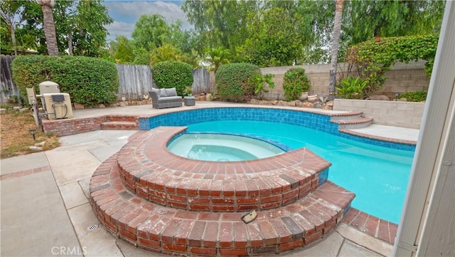 view of pool with a patio area and an in ground hot tub