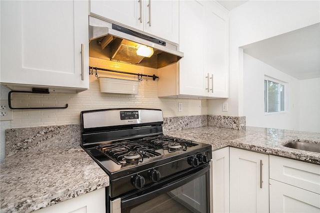 kitchen with light stone counters, black gas range oven, and white cabinetry