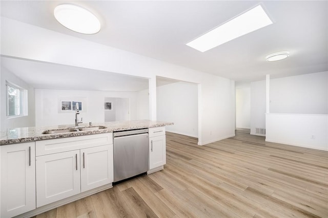 kitchen with white cabinets, stainless steel dishwasher, light stone countertops, and sink