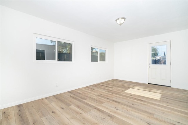 empty room with light hardwood / wood-style floors and a wealth of natural light